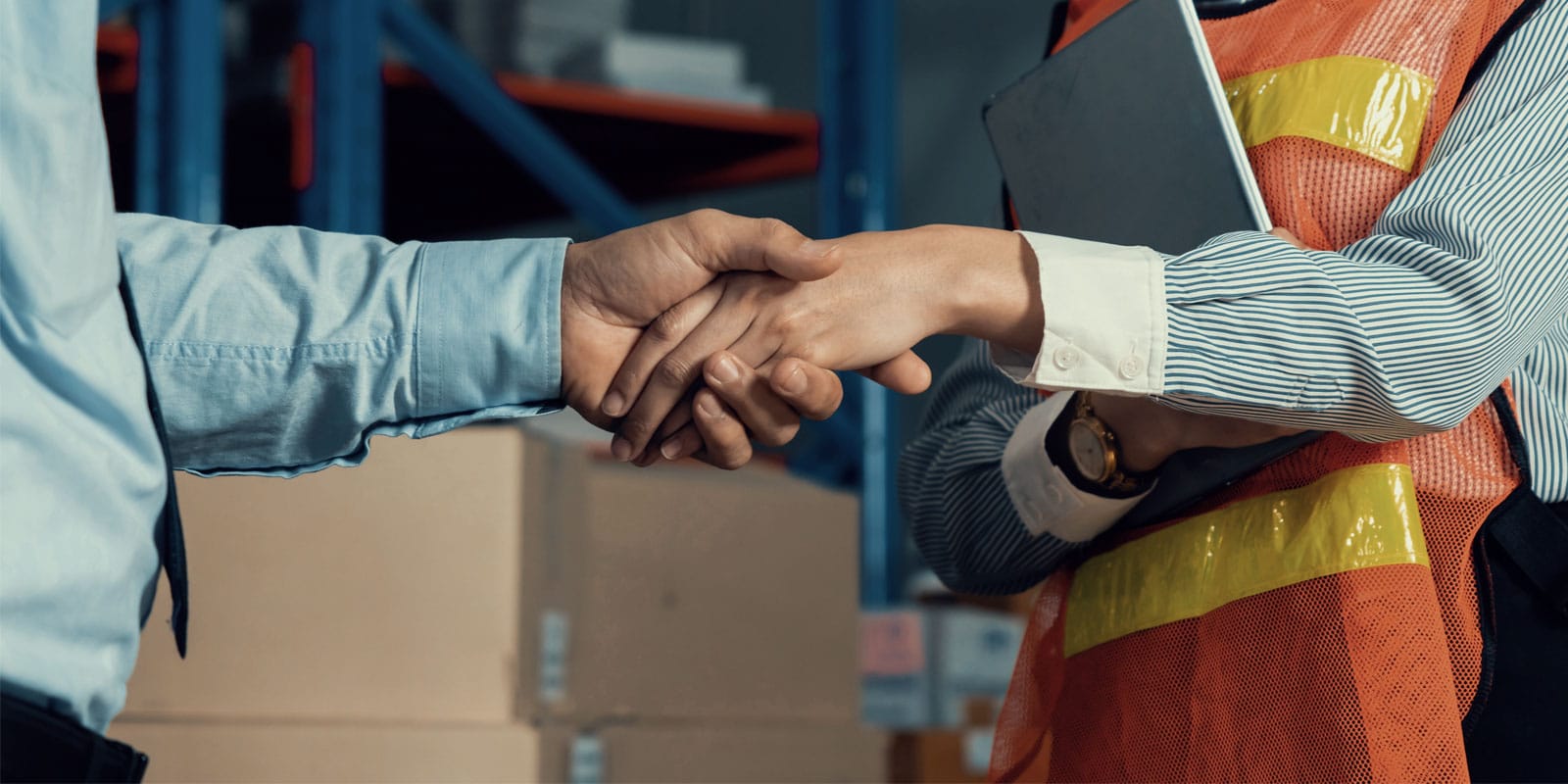 Business person shaking hands with a field worker