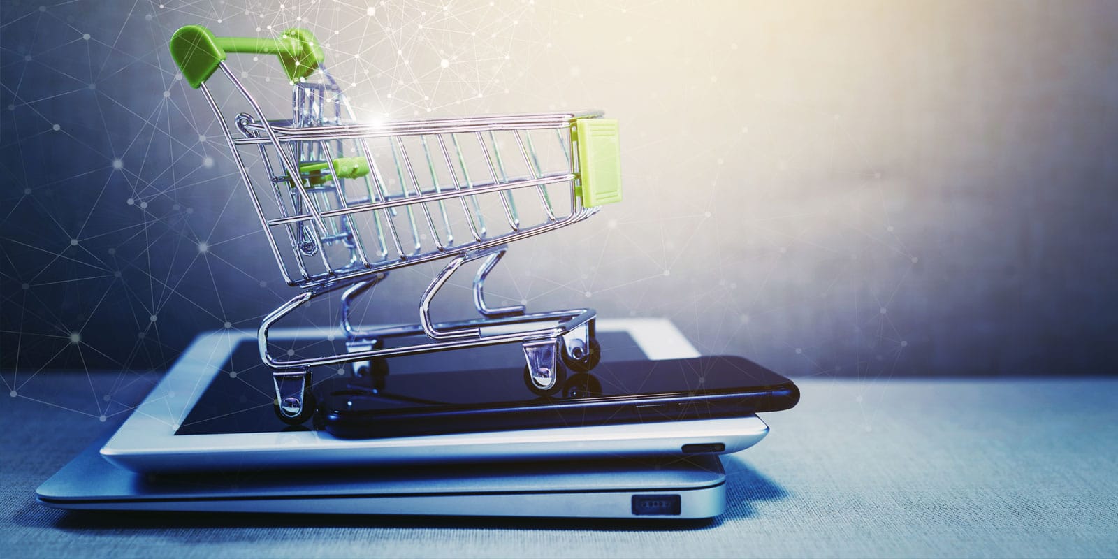 shopping cart on top of digital devices, phone, tablet, laptop