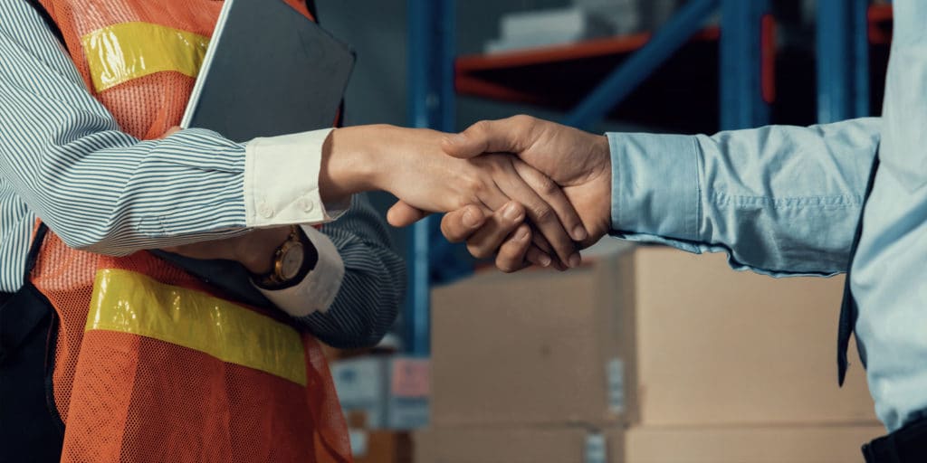 sales person shaking worker's hand